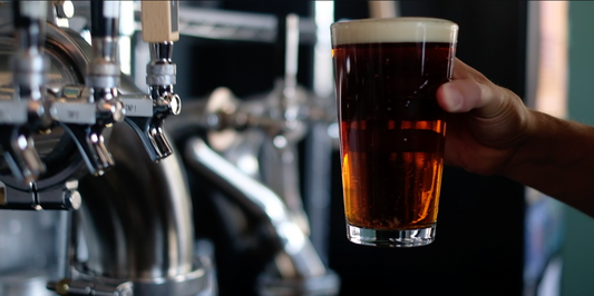 Close-up of a freshly poured amber Oktoberfest beer from a tap at Unhinged Brewing, showcasing the brewery’s signature craft beer experience